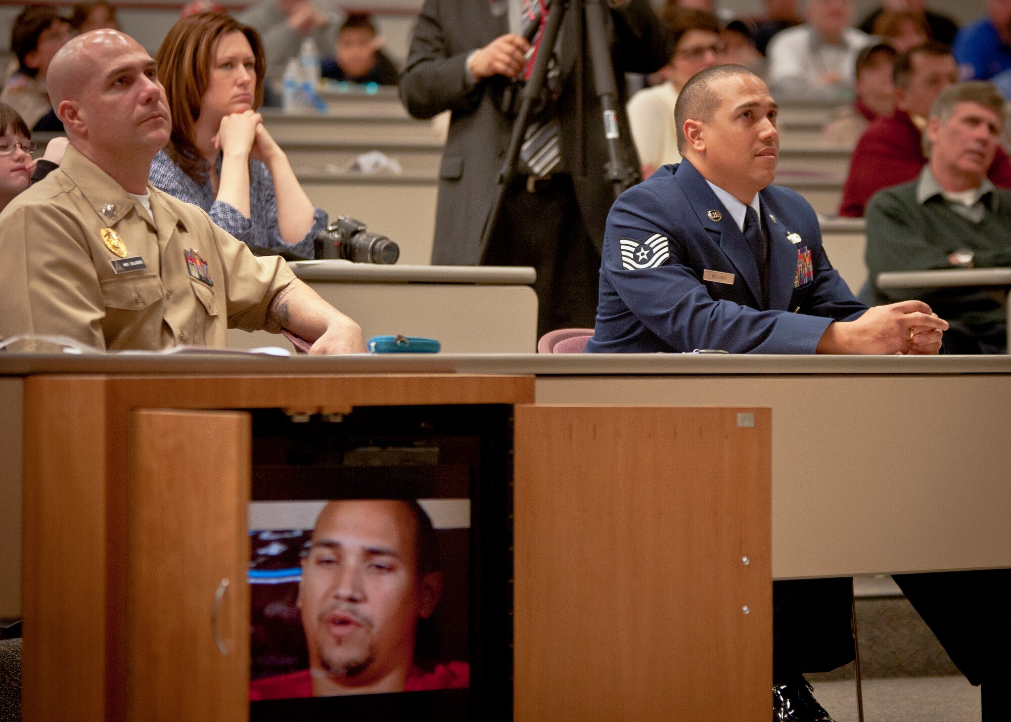 (Right) Tech. Sgt. Brian Williams, 87th Security Forces Squadron military working dog handler, watches a video of himself at the second annual K-9 Veterans Day celebration March 14, 2014, at the Bergen County Law and Public Safety Institute in Mahwah, N.J. Williams, a wounded warrior, viewed a video that retold his story of being seriously injured during a 2012 mission in Southern Afghanistan. He was made an honorary member of the county and awarded the Bergen County Military Service Medal. (U.S. Air Force photo/Staff Sgt. Scott Saldukas)