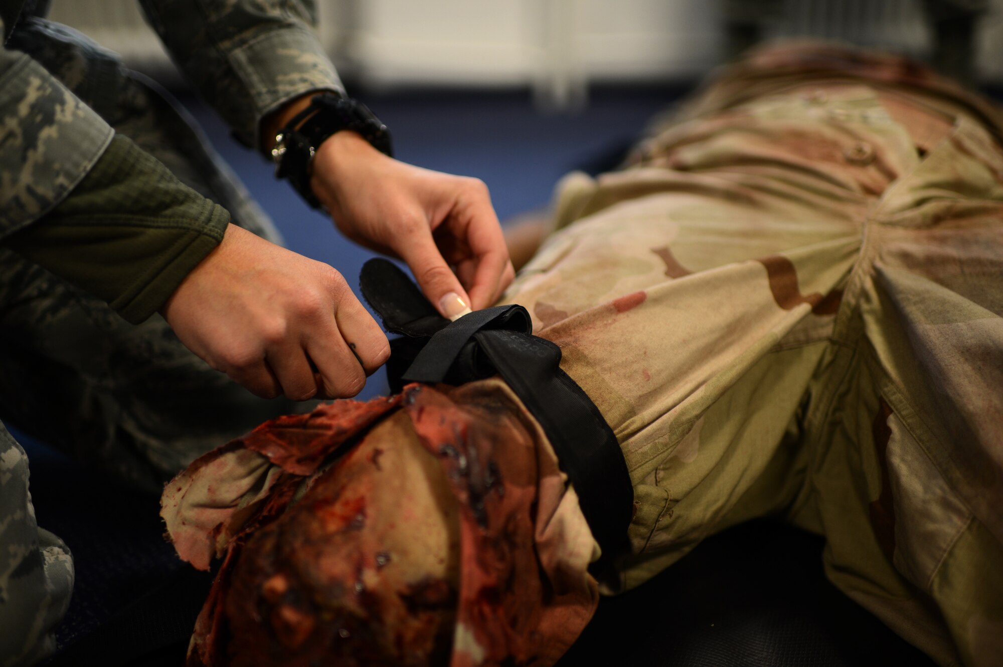 U.S. Air Force Staff Sgt. Elizabeth Butler, 52nd Medical Operations Squadron aerospace medical technician from Tampa, Fla., applies a tourniquet to a mock patient during a skills training class March 19, 2014 at Spangdahlem Air Base, Germany. Medical technicians must remain proficient in an array of medical services, regardless of their current occupation. This quarterly training included evaluation stations ranging from roadside-bomb injuries to basic clinic patient care. (U.S. Air Force photo by Senior Airman Gustavo Castillo/Released)