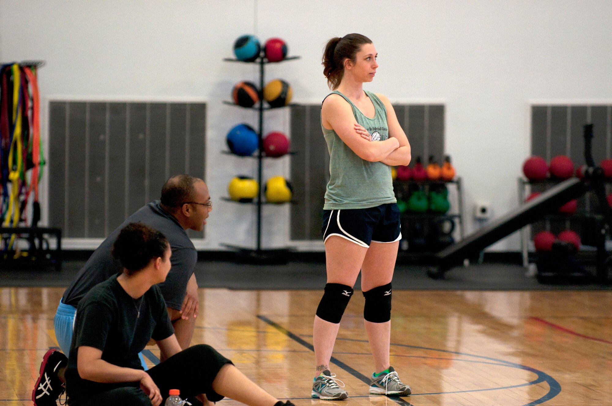 Kimberly Wood, 90th Force Support Squadron volleyball team member, along with two teammates, rest on the sidelines until they can get back in the intramural volleyball game their team is playing in the Freedom Hall Fitness Center March 18, 2014. (U.S. Air Force photo by Airman Malcolm Mayfield)