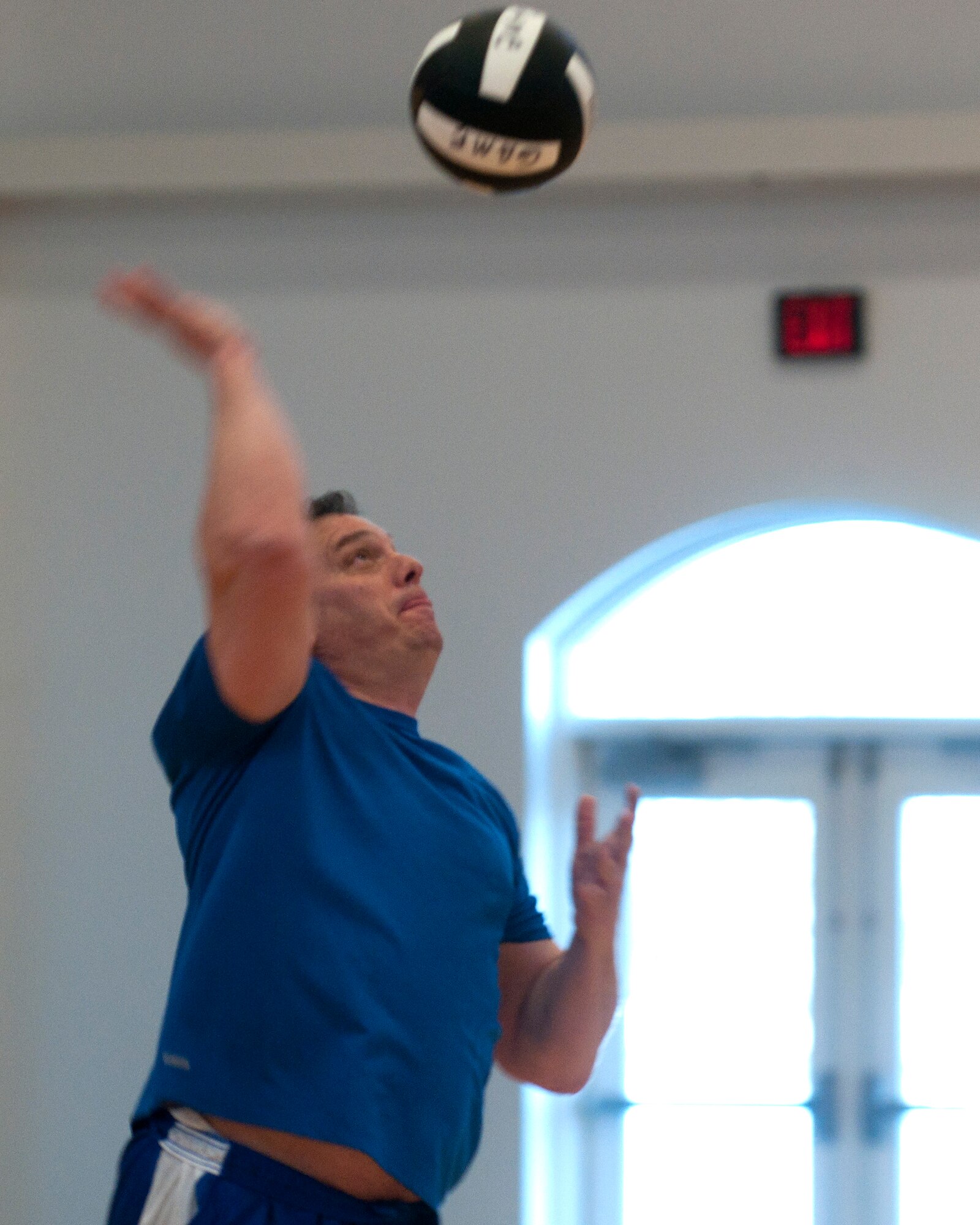 Richard Spence, 90th Communication Squadron volleyball team member, serves the ball during an intramural volleyball game in the Freedom Hall Fitness Center March 18, 2014. The 90th CS volleyball team currently has 5 wins and 2 losses. (U.S. Air Force photo by Airman Malcolm Mayfield)