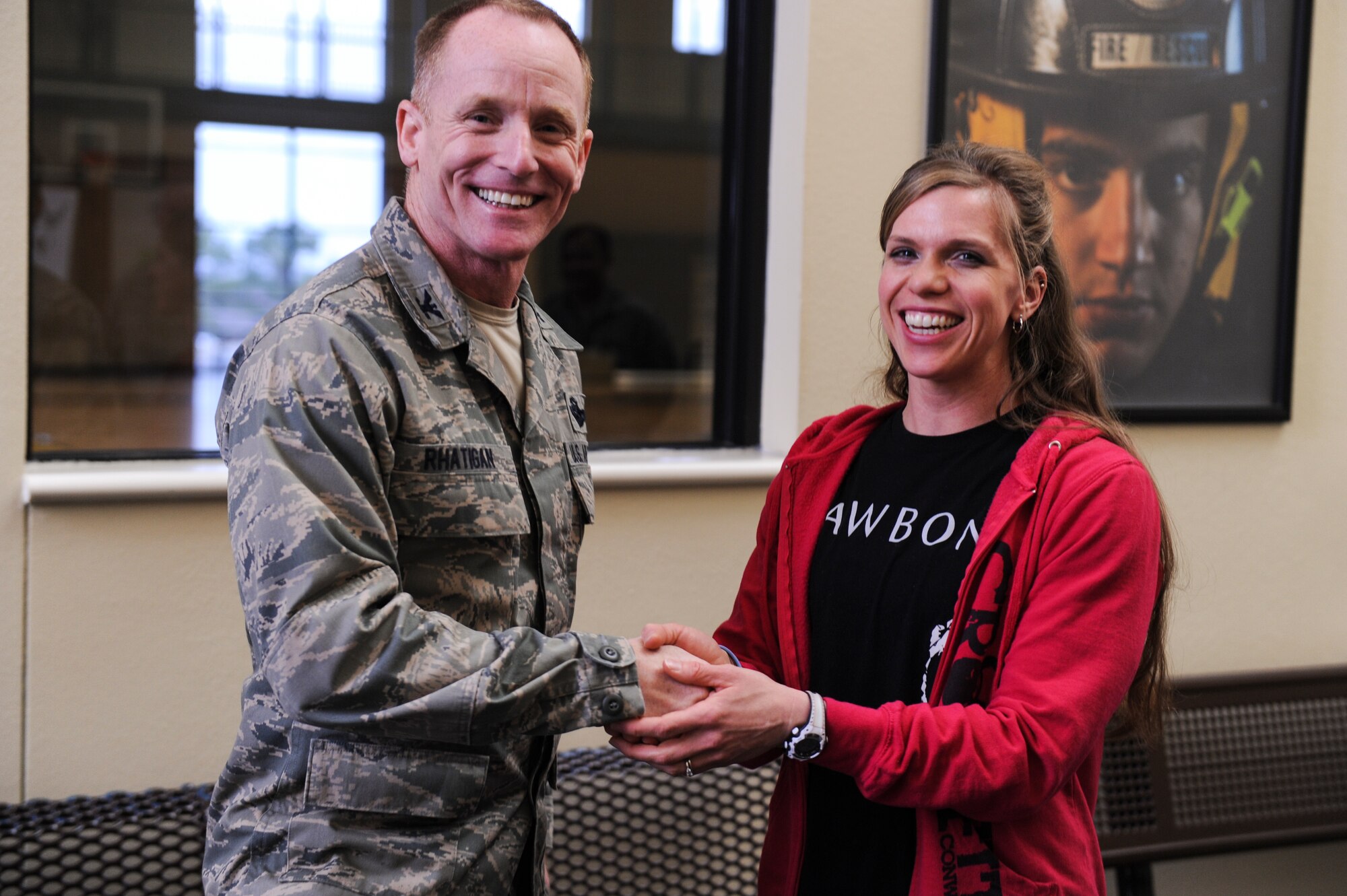 Col. Patrick Rhatigan, 19th Airlift Wing commander, coins Lindsay Burks, a 19th Aerospace Medicine Squadron health and fitness specialist, for her selection as Combat Airlifter of the Week March 17, 2014, at Little Rock Air Force Base, Ark. Burks conducts classes educating Team Little Rock Airmen on diabetes management, prenatal fitness and running improvement. She also accomplishes individual fitness training.  (U.S. Air Force photo by Airman 1st Class Cliffton Dolezal) 