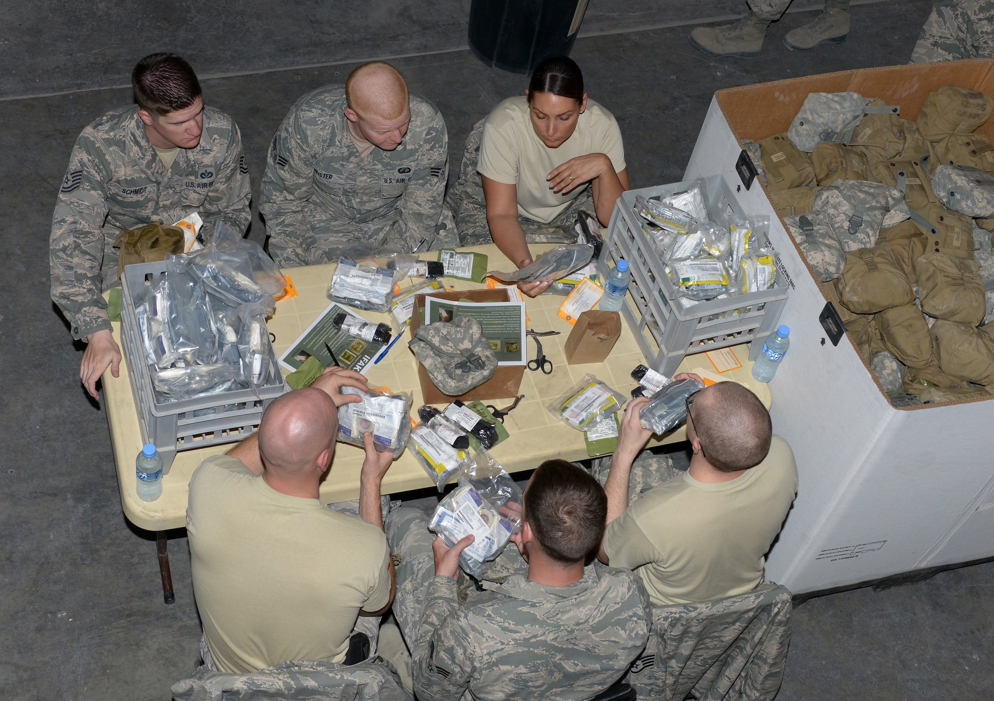 Airmen deployed to the 379th Air Expeditionary Wing volunteer to re-certify Individual First Aid Kits at Al Udeid Air Base, Qatar, Mar. 14, 2014. Service members who deploy are issued IFAKs for temporary medical assistance, until they can reach further medical care. All items inside the IFAK that expire within a year must be replaced before they can be re-certified. Once items inside the IFAK have been verified, they are sealed with a tag and service receipt to guarantee the IFAK has not been tampered with. (U.S. Air Force photo/Senior Airman Hannah Landeros)