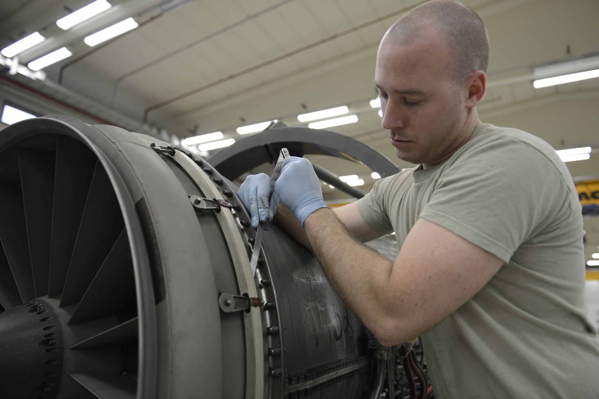 U.S. Air Force Airman 1st Class Jordan Schultz, 52nd Component Maintenance Squadron aerospace propulsion journeyman from Westminster, Md., checks the fan inlet guide vane actuation ring and spacer for proper clearances, March 18, 2014, at Spangdahlem Air Base, Germany. Maintaining the critical clearances in the engine ensures proper operation of the engine. (U.S. Air Force photo by Staff Sgt. Christopher Ruano/Released)