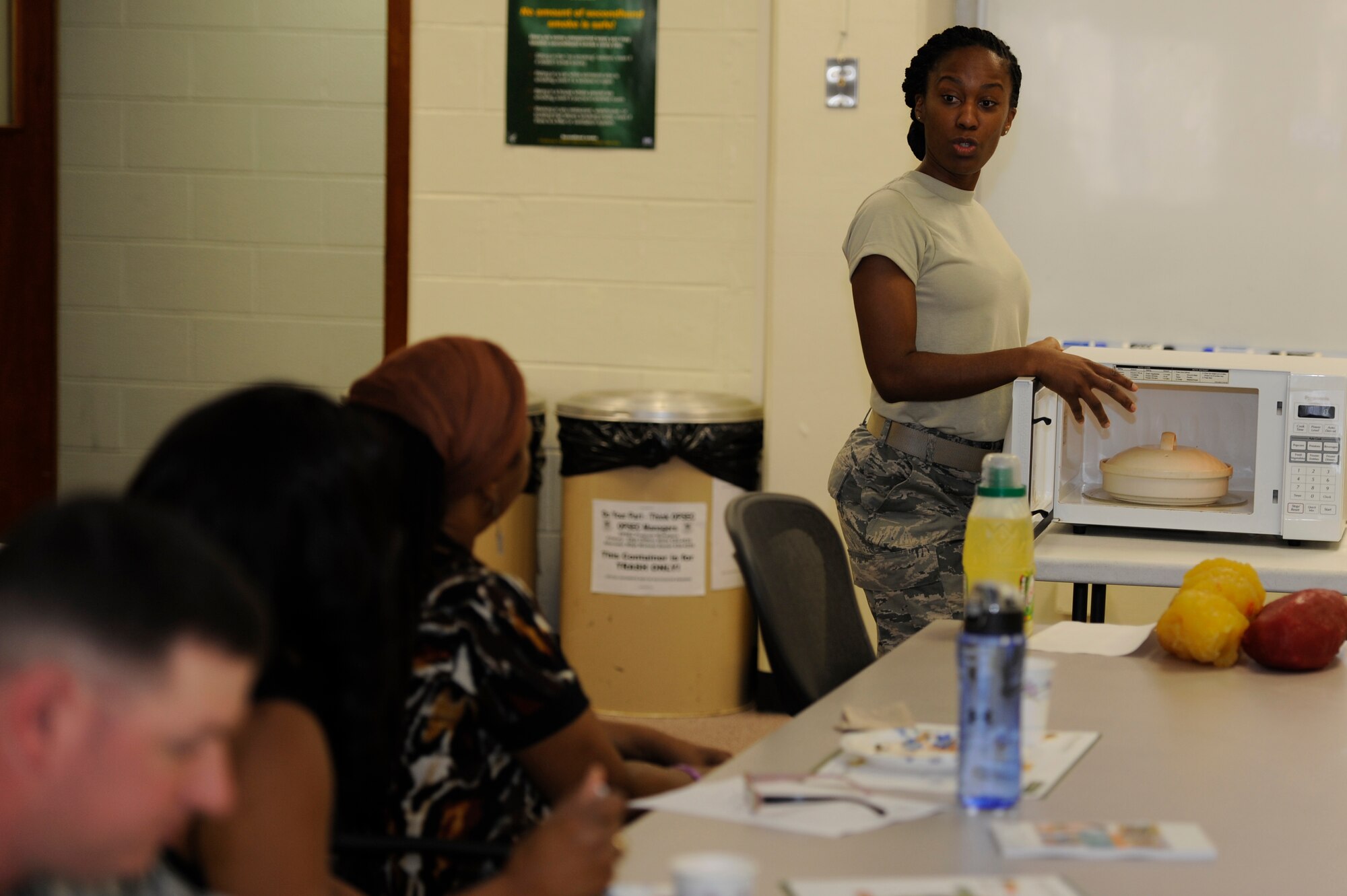 U.S. Air Force Tech. Sgt. Jennifer Randolph, 18th Aerospace Medicine Squadron diet technician, demonstrates how to prepare and cook wild salmon in a microwave during a healthy cooking demonstration at the Health and Wellness Center on Kadena Air Base, Japan, March 19, 2014. The cooking class was in celebration of National Nutrition Month. (U.S. Air Force photo by Senior Airman Marcus Morris)