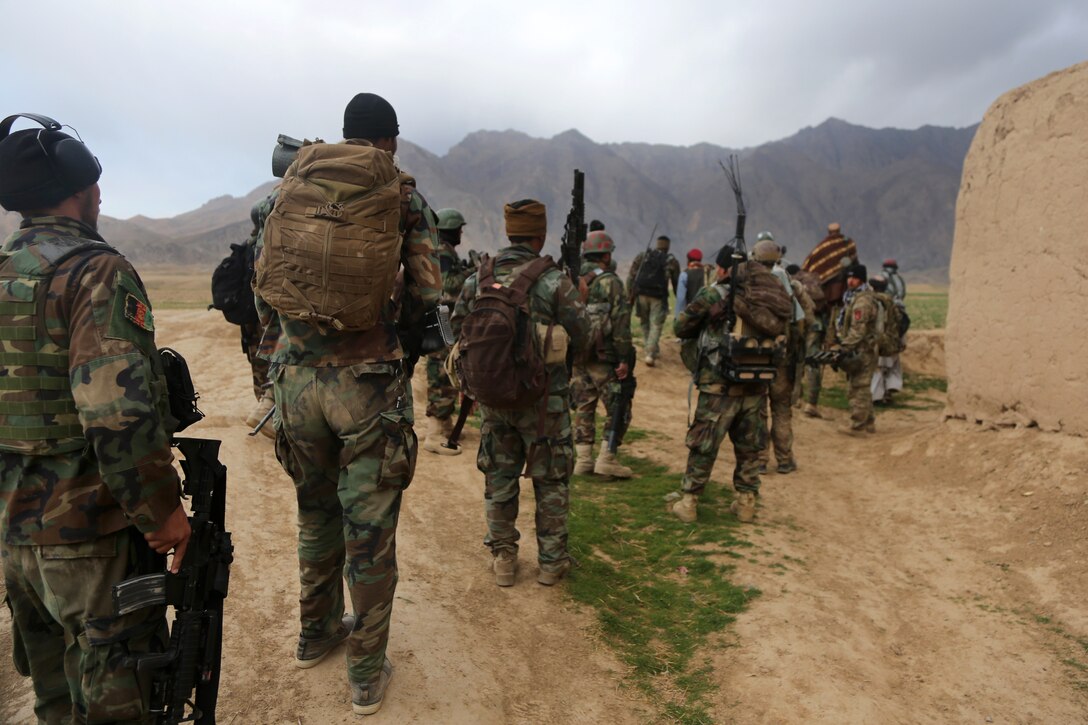 Afghan commandos walk to a compound during a clearance operation in ...