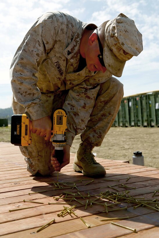 Cpl. Joseph M. Fowden, a combat engineer with Combat Logistics Battalion 11, 11th Marine Expeditionary Unit, drives a screw into lumber for a footbridge to be used by local citizens starting March 22. The bridge was built to be transported for an upcoming community relations project initiated by the chaplains of the 11th MEU.  The 11th MEU is at Fort Hunter Liggett, Calif. conducting Realistic Urban Training Marine Expeditionary Unit 14-1 (RUTMEUEX) as part of their preparation for the deployment scheduled for later this year. (U.S. Marine Corps photo by Lance Cpl. Laura Y. Raga/Released)