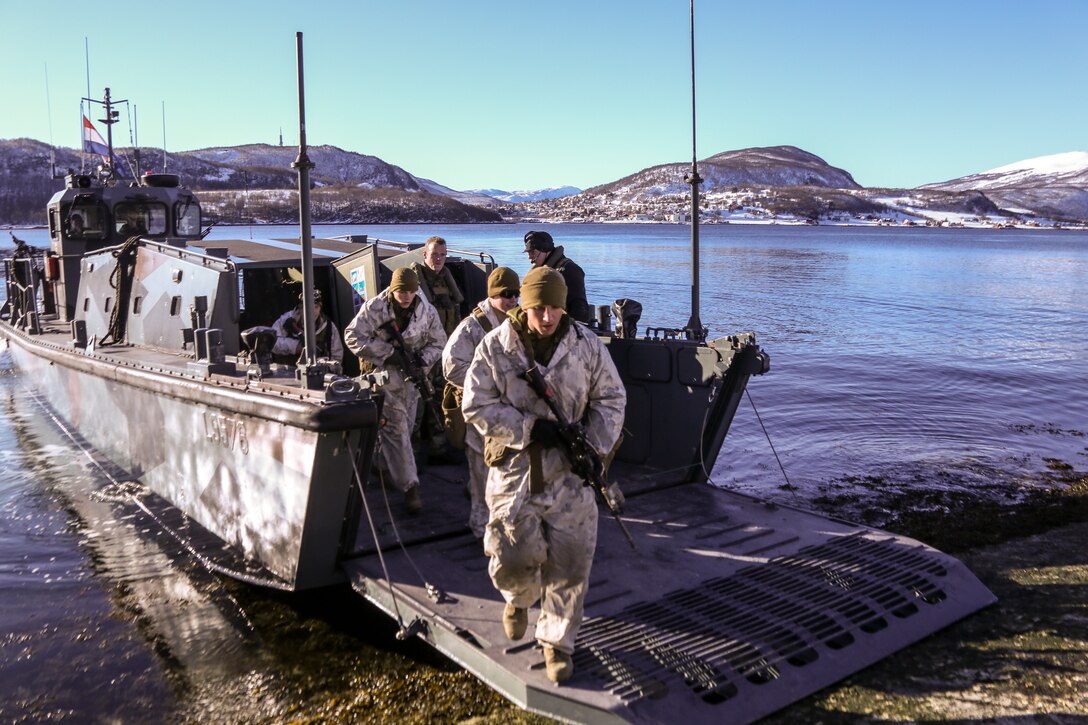 Lance Cpl. Jon Gillis, a Washington D.C., native and a machine gunner with Weapons Company, 2nd Battalion, 2nd Marine Regiment, 2nd Marine Division, storms the beach during an amphibious raid rehearsal March 17, 2014. Marines from 2nd Battalion, 2nd Marine Regiment, 2nd Marine Division and Norwegian soldiers spent two days spent aboard the HNLS Rotterdam to train with Dutch sailors and marines for the amphibious raid during Cold Response 14, a multinational and multilateral training exercise featuring various types of military training including maritime, land and air operations. The location, above the Arctic Circle in northern Norway, provides a unique cold-weather environment for all forces involved to learn and develop procedures from an international contingent of allies.