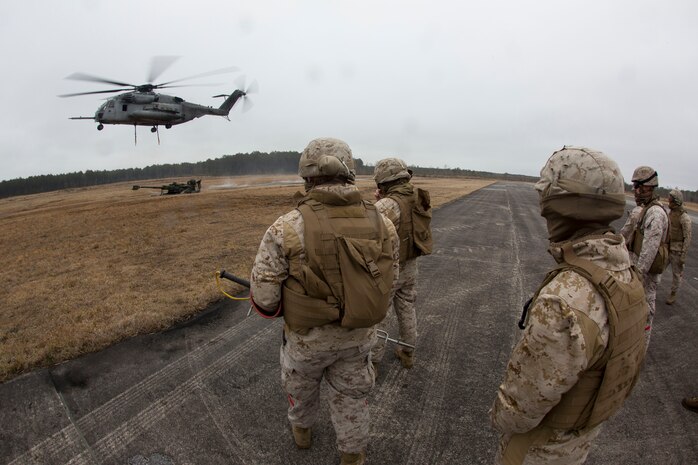 Landing support specialists with Combat Logistics Regiment 2, 2nd Marine Logistics Group, II Marine Expeditionary Force approach a M777 howitzer during a Helicopter Support Team exercise at Davis Airfield aboard Camp Lejeune, N.C., March 19, 2014. A CH-53E Super Stallion from Marine Heavy Helicopter Squadron 461, Marine Aircraft Group 29, Marine Corps Air Station New River, conducted the lifts throughout the training evolution. 