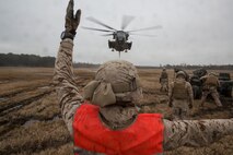 A landing support specialist with Combat Logistics Regiment 2, 2nd Marine Logistics Group, II Marine Expeditionary Force gives hand and arm signals to a CH-53E Super Stallion from Marine Heavy Helicopter Squadron 461, Marine Aircraft Group 29, Marine Corps Air Station New River, during a Helicopter Support Team exercise at Davis Airfield aboard Camp Lejeune, N.C., March 19, 2014. 1st Battalion, 10th Marine Regiment brought two M777 howitzers for 2nd MLG Marines to train with.