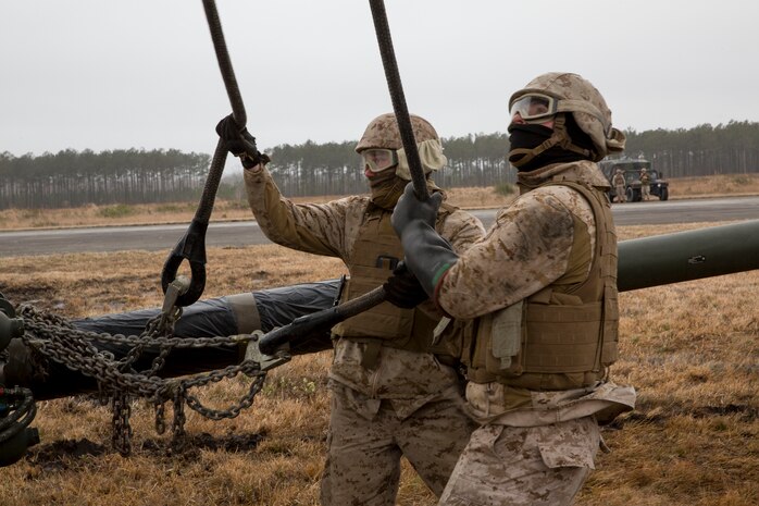 Landing support specialists with Combat Logistics Regiment 2, 2nd Marine Logistics Group, II Marine Expeditionary Force check the cables connecting to a M777 howitzer during a Helicopter Support Team exercise at Davis Airfield aboard Camp Lejeune, N.C., March 19, 2014. A CH-53E Super Stallion from Marine Heavy Helicopter Squadron 461, Marine Aircraft Group 29, Marine Corps Air Station New River, conducted the lifts throughout the training evolution. 