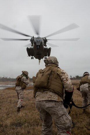 Landing support specialists with Combat Logistics Regiment 2, 2nd Marine Logistics Group, II Marine Expeditionary Force wait for the CH-53E Super Stallion from Marine Heavy Helicopter Squadron 461, Marine Aircraft Group 29, Marine Corps Air Station New River, to hover over the M777 howitzer during a Helicopter Support Team exercise at Davis Airfield aboard Camp Lejeune, N.C., March 19, 2014. 1st Battalion, 10th Marine Regiment brought two M777s for 2nd MLG Marines to train with.
