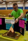 A Marine volunteer at the science fair in Jacksonville, N.C., demonstrates how to make a volcano March 15, 2014. Marines with General Support Maintenance Company, 2nd Maintenance Battalion, 2nd Marine Logistics Group volunteered time during their weekend at several locations throughout the area as a way to give back to the community that surrounds Marine Corps Base Camp Lejeune, N.C.