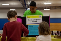 A Marine volunteer with General Support Maintenance Company, 2nd Maintenance Battalion, 2nd Marine Logistics Group teaches area children how magnets work during a science fair in Jacksonville, N.C., March 15, 2014. Thirty Marines with the company volunteered time during their weekend at several locations throughout the area as a way to give back to the community that surrounds Marine Corps Base Camp Lejeune, N.C.