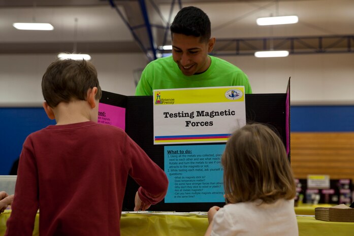 A Marine volunteer with General Support Maintenance Company, 2nd Maintenance Battalion, 2nd Marine Logistics Group teaches area children how magnets work during a science fair in Jacksonville, N.C., March 15, 2014. Thirty Marines with the company volunteered time during their weekend at several locations throughout the area as a way to give back to the community that surrounds Marine Corps Base Camp Lejeune, N.C.