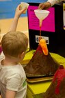 A young visitor to a science fair in Jacksonville, N.C., creates a volcano with the help of volunteers March 15, 2014. Marines with General Support Maintenance Company, 2nd Maintenance Battalion, 2nd Marine Logistics Group volunteered at several locations throughout the area as a way to give back to the community that surrounds Marine Corps Base Camp Lejeune, N.C.