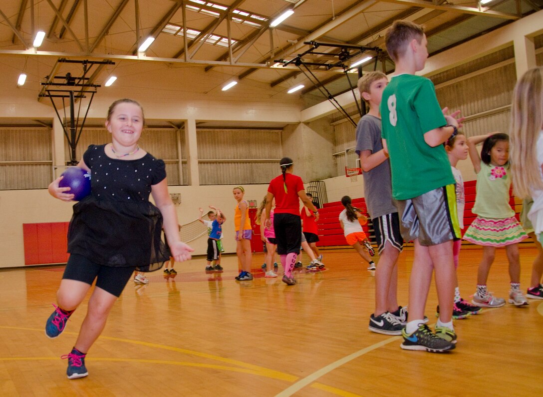 Villy Kitzmiller, 8, runs around a circle of her peers while playing “Around the World” during KidFit at the Semper Fit Center gym, March 17, 2014. (U.S. Marine Corps photo by Kristen Wong)