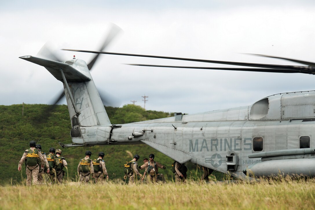 Reconnaissance Marines and sailors board a CH-53E Super Stallion assigned to Marine Heavy Helicopter Squadron 463 as they prepare to conduct a low-level static line jump package on the fl ight line on Marine Corps Air Station Kaneohe Bay, March 18, 2014. At an altitude between 1,500 feet to 2,000 feet, three to four service members jumped each time as the aircraft flew over the area. (U.S. Marine Corps photo by Lance Cpl. Matthew J. Bragg)