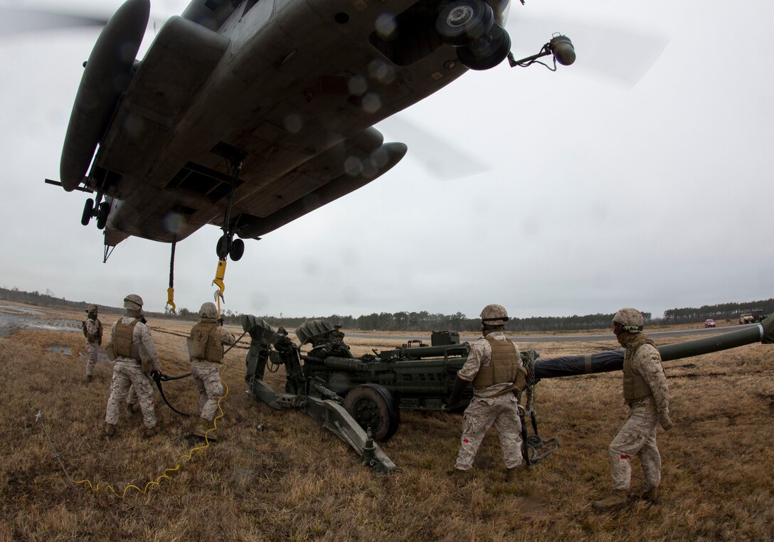Landing support specialists with Combat Logistics Regiment 2, 2nd Marine Logistics Group, II Marine Expeditionary Force connect cables to a CH-53E Super Stallion from Marine Heavy Helicopter Squadron 461, Marine Aircraft Group 29, Marine Corps Air Station New River, during a Helicopter Support Team exercise at Davis Airfield aboard Camp Lejeune, N.C., March 19, 2014. 1st Battalion, 10th Marine Regiment brought two M777 howitzers for 2nd MLG LS specialists to train with. 