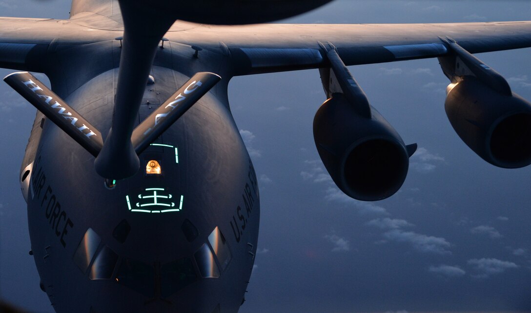 A C-17 Globemaster III is guided into position behind the boom of a KC-135 Stratotanker in order to receive fuel during an in-air refueling training mission near Joint Base Pearl Harbor-Hickam, Hawaii, March 20, 2014. The boom was guided by Airman 1st Class Rebekah McCormack, 96th Air Refueling Squadron in-flight refueling specialist, during her training on refueling procedures. (U.S. Air Force photo/Staff Sgt. Alexander Martinez)