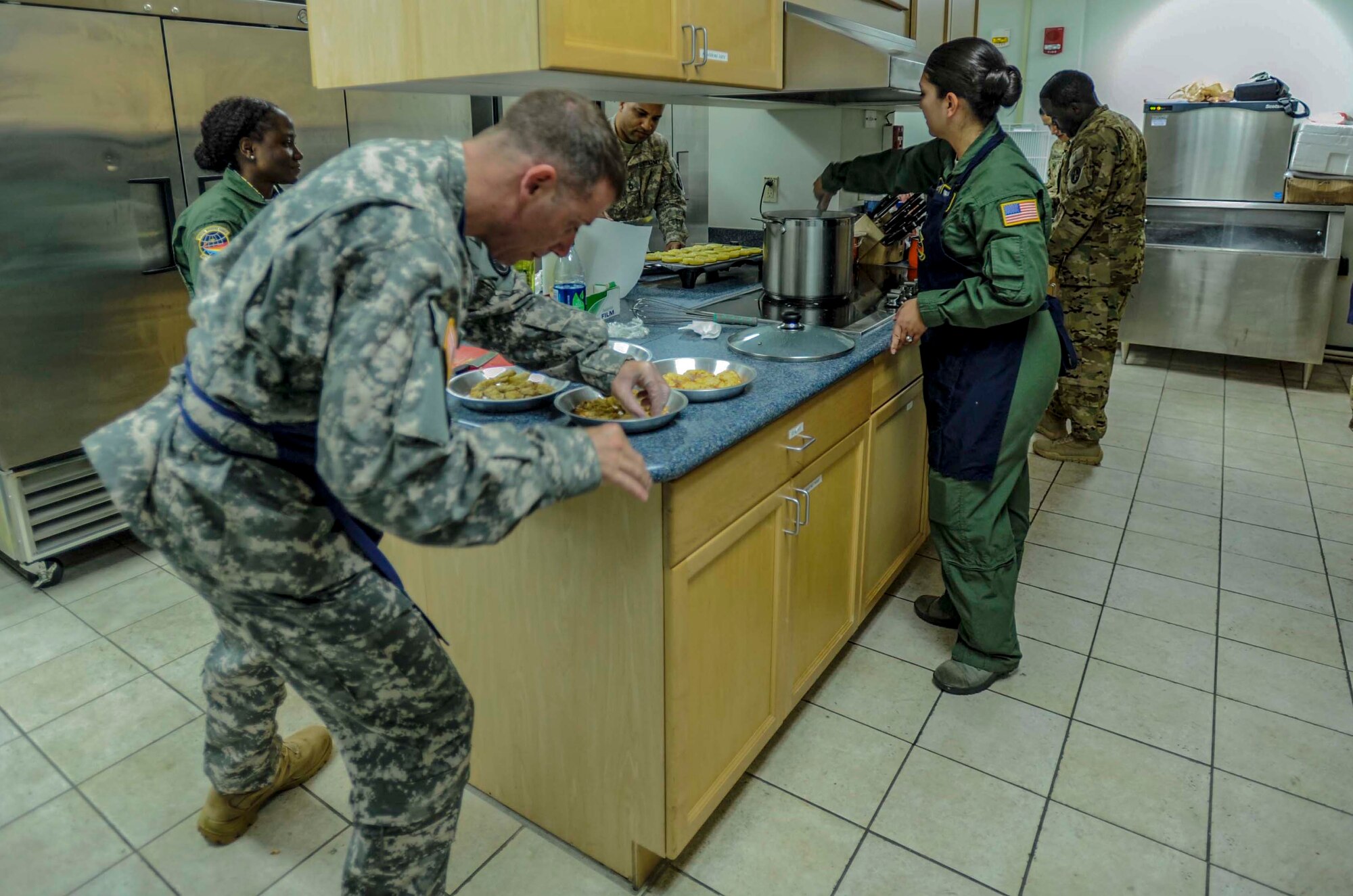 Airmen and Soldier flight attendants from the 65th Airlift Squadron and U.S. Army Priority Air Detachment prepare food in the 65th AS flight kitchen on Joint Base Pearl Harbor-Hickam, Hawaii, March 19, 2014. The food will be served as part of a seven-course Joint Service Flight Culinary Training Meal. The flight culinary training meals are part of an ongoing effort between the two services to maximize on-the-job training opportunities and increase camaraderie and cross-flow of communication between the units. (U.S. Air Force photo/Tech. Sgt. Terri Paden)