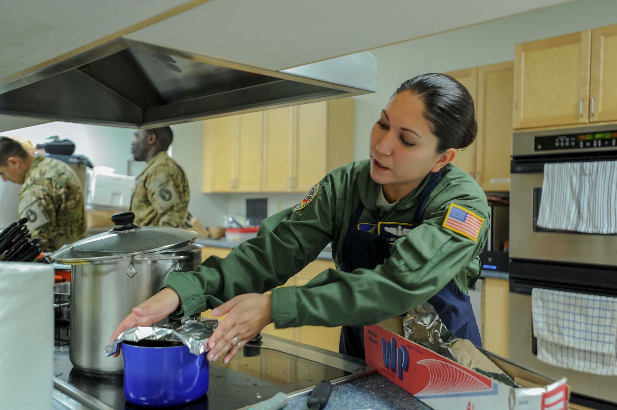 Tech. Sgt. Melissa Derrick, 65th Airlift Squadron flight attendant, places foil over a pot of sweet corn puree in preparation for serving it at the 65th AS flight kitchen on Joint Base Pearl Harbor-Hickam, Hawaii, March 19, 2014. The dish will be served as part of a seven-course Joint Service Flight Culinary Training Meal. The flight culinary training meals are part of an ongoing effort between the two services to maximize on-the-job training opportunities and increase camaraderie and cross-flow of communication between the units. (U.S. Air Force photo/Tech. Sgt. Terri Paden)