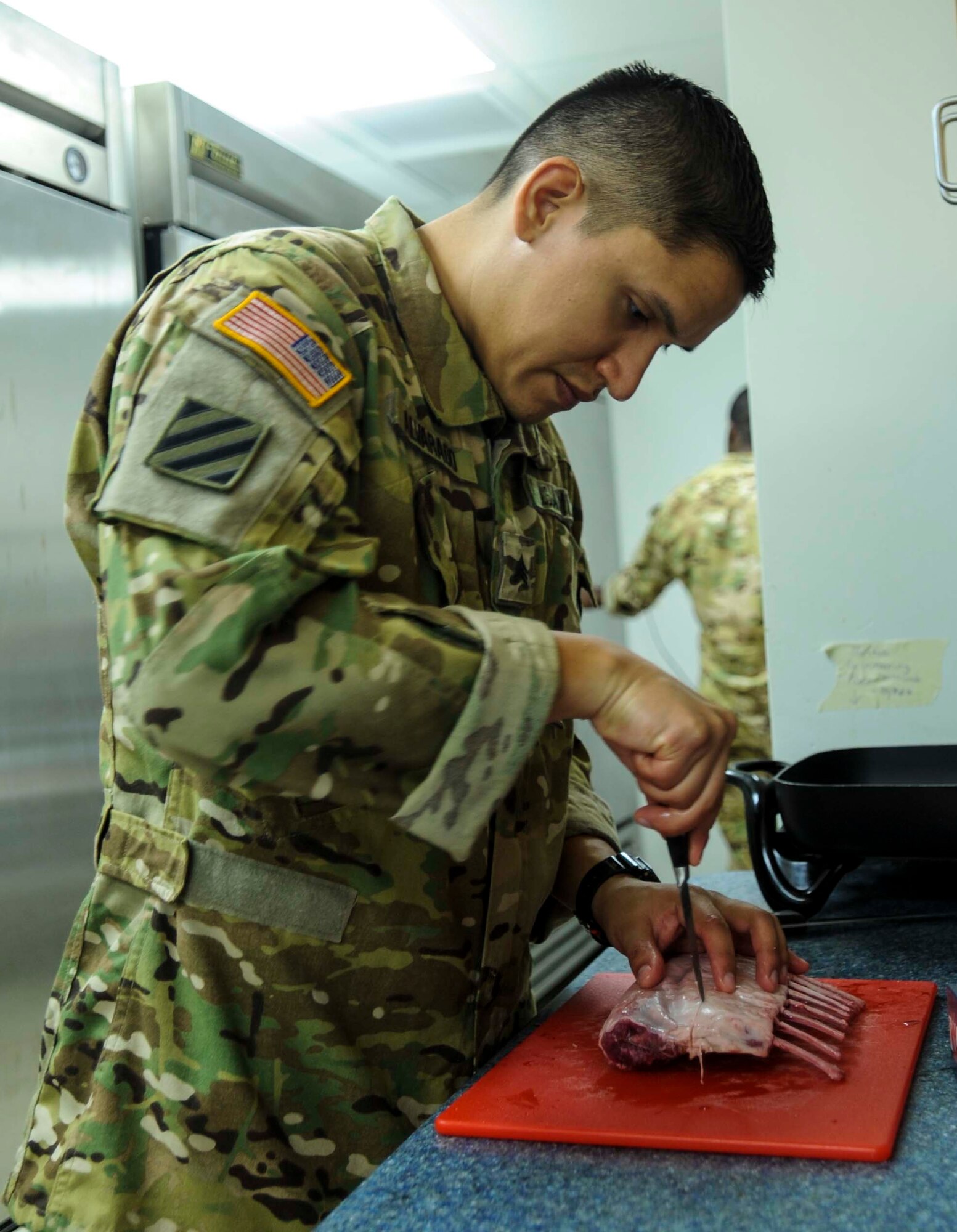 Army SGT. Oscar Alvarado, U.S. Army Priority Air Detachment flight steward, cuts the fat off a rack of lamb in the 65th Airlift Squadron flight kitchen on Joint Base Pearl Harbor-Hickam, Hawaii, March 19, 2014. Alvarado is preparing lamb chops for a Joint Service Flight Culinary Training Meal. The flight culinary training meals are part of an ongoing effort between the two services to maximize on-the-job training opportunities and increase camaraderie and cross-flow of communication between the units. (U.S. Air Force photo/Tech. Sgt. Terri Paden)