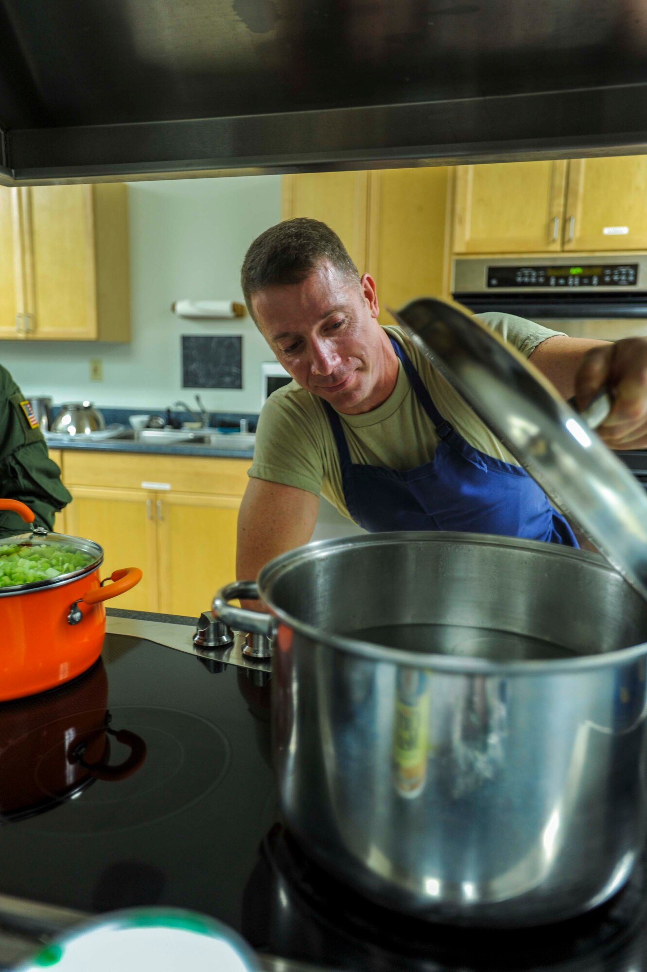 Army Staff SGT. Steve Harper, Jr., U.S. Army Priority Air Detachment flight steward, checks to see if a pot of water is boiling in the 65th Airlift Squadron flight kitchen on Joint Base Pearl Harbor-Hickam, Hawaii, March 19, 2014. Harper is boiling water to make minestrone soup for a Joint Service Flight Culinary Training Meal. The flight culinary training meals are part of an ongoing effort between the two services to maximize on-the-job training opportunities and increase camaraderie and cross-flow of communication between the units. (U.S. Air Force photo/Tech. Sgt. Terri Paden)