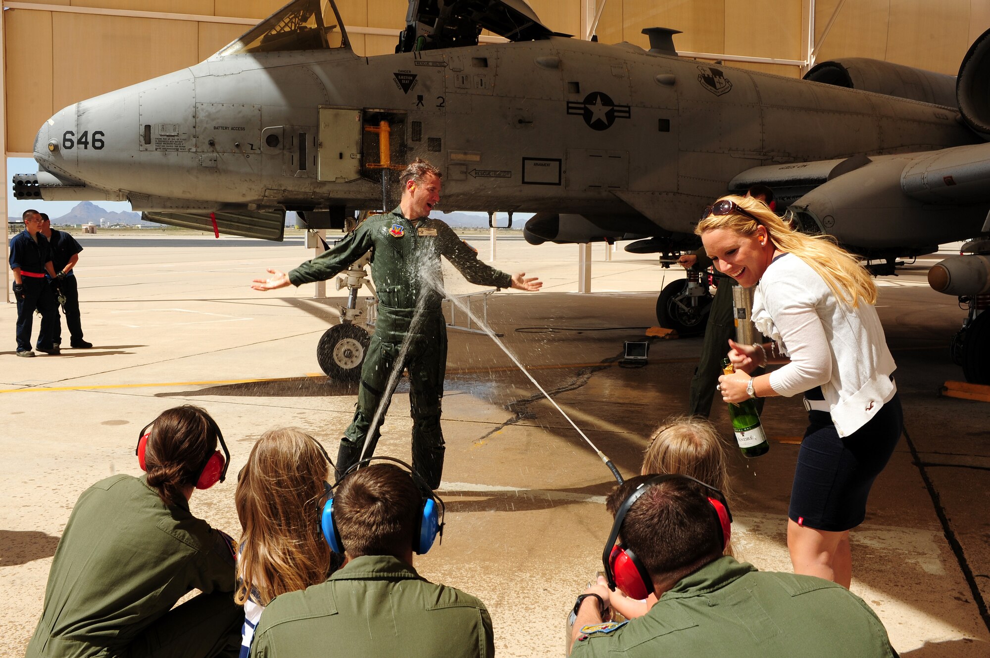 German Maj. Andreas Jeschek, 354th Fighter Squadron assistant director of operations, is sprayed with champagne and water after disembarking an A-10 Thunderbolt during his final flight ceremony at Davis-Monthan Air Force Base, Ariz., March 21, 2014. Jeschek deployed with the Bulldogs to Afghanistan, and flew close to 100 missions. (U.S. Air Force photo by Senior Airman Camilla Elizeu/Released)