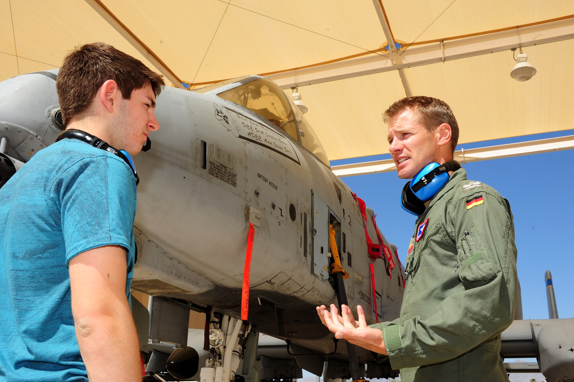 German Maj. Andreas Jeschek, 354th Fighter Squadron assistant director of operations, talks to a German Exchange student in their native tongue about the A-10 Thunderbolt at Davis-Monthan Air Force Base, Ariz., March 19, 2014. Maj. Jeschek is a North Atlantic Treaty Organization officer that was given the opportunity to foster a bilateral relationship through the Exchange Officer Program. (U.S. Air Force photo by Senior Airman Camilla Elizeu/Released)