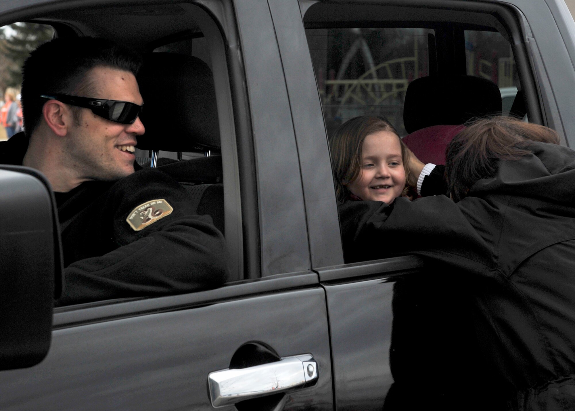 Tech. Sgt. Nick Bowater, 22nd Training Squadron Survival, Evasion, Resistance and Escape instructor, looks on as his daughter London is greeted by a loved one. Hundreds of students, teachers and military family members lined up in support of London as she traveled to Seattle, Wash. to begin treatment for the second time. London, diagnosed with Acute Lymphoblastic Leukemia, was just six months away from completing treatment when her family received word her cancer had returned. (U.S. Air Force photo by Senior Airman Mary O'Dell/Released)