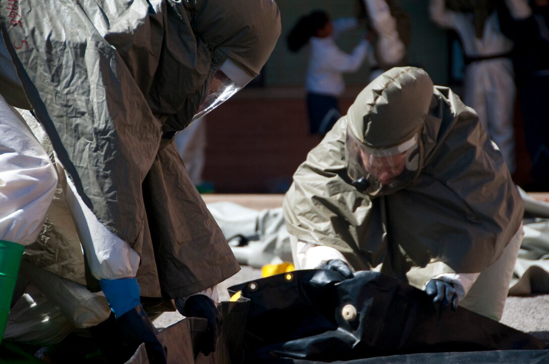 82nd Medical Group Airmen set up a containment berm for waste water during a decontamination exercise March 13. The decontamination team had 20 minutes to assemble the shelter, get the water heater running, and have every member in their personal protective gear. The exercise was meant to enhance readiness for the unexpected and bring unity to the team. (U.S. Air Force photo/Airman 1st Class Robert L. McIlrath)