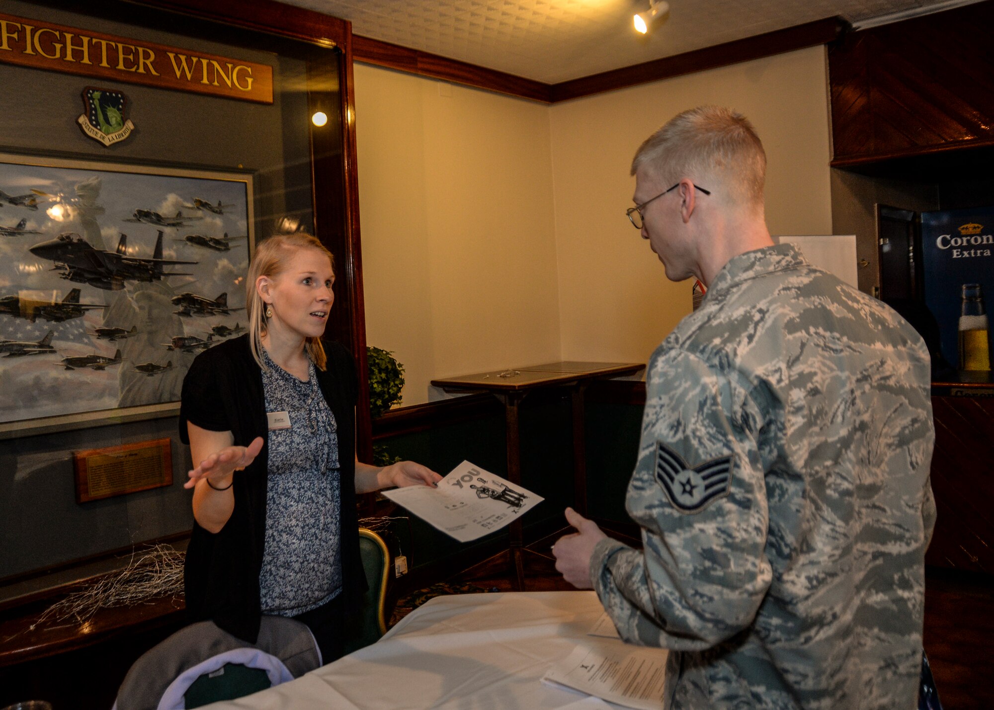 Karie Duggan-Childs, Human Resources assistant for Army and Air Force Exchange Service, provides Staff Sgt. John Leavelle, 48th Logistics Readiness Squadron central storage supervisor, with information to take to his wife, during the Employment and Volunteer Fair at Eagle’s Landing on Royal Air Force Lakenheath, England, March, 19, 2014. The fair provided civilian and military personnel with insight on job and volunteer opportunities provided on base and in the local area. (U.S. Air Force photo by Airman 1st Class Nigel Sandridge/Released)