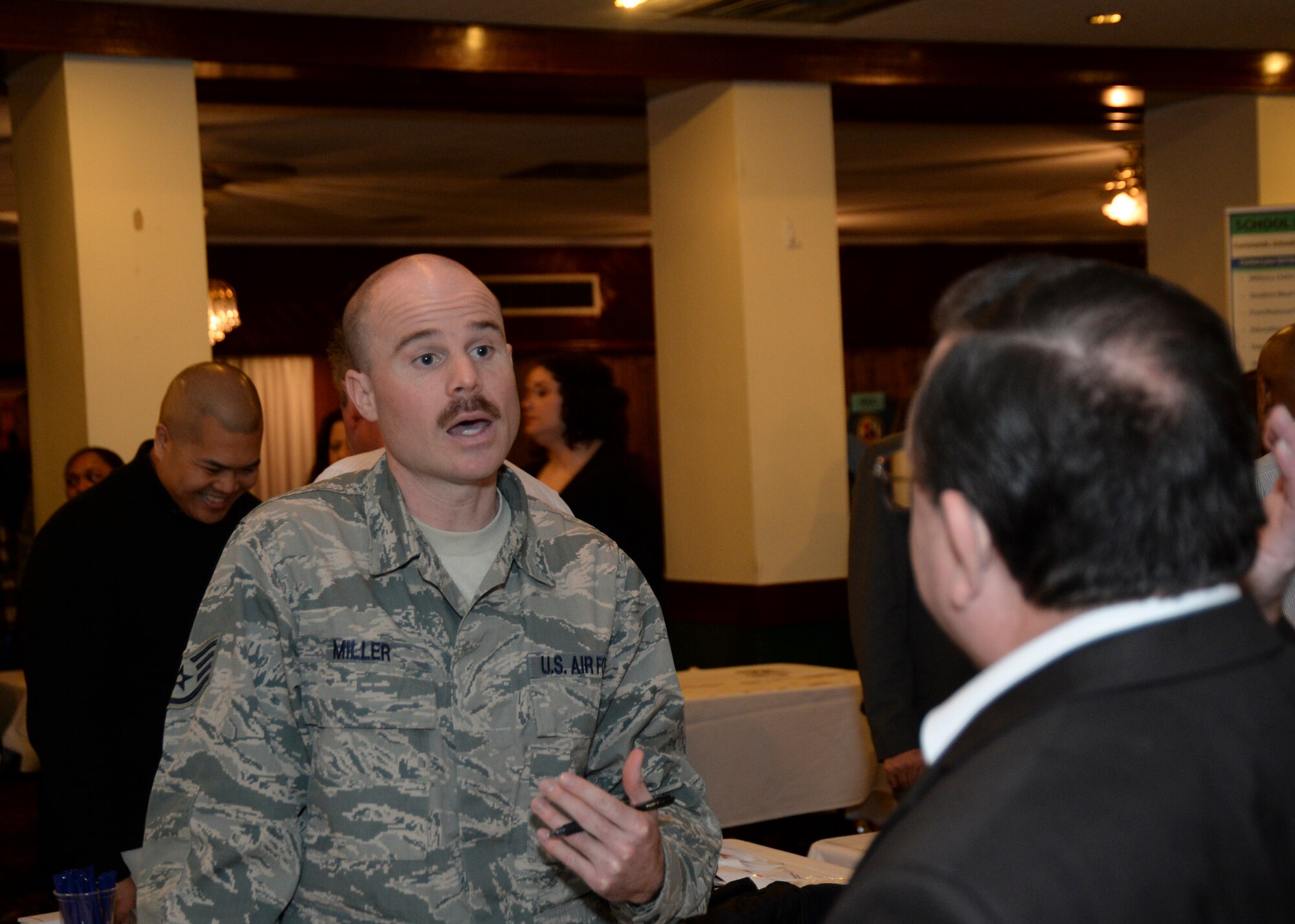 Staff Sgt. David Miller, 48th Contracting Squadron contractor, talks to an individual about his job and available positions at the Employment and Volunteer Fair at Eagle’s Landing on Royal Air Force Lakenheath, England, March, 19, 2014. The fair provided civilian and military personnel with insight on job and volunteer opportunities provided on base and in the local area. (U.S. Air Force photo by Airman 1st Class Nigel Sandridge/Released)