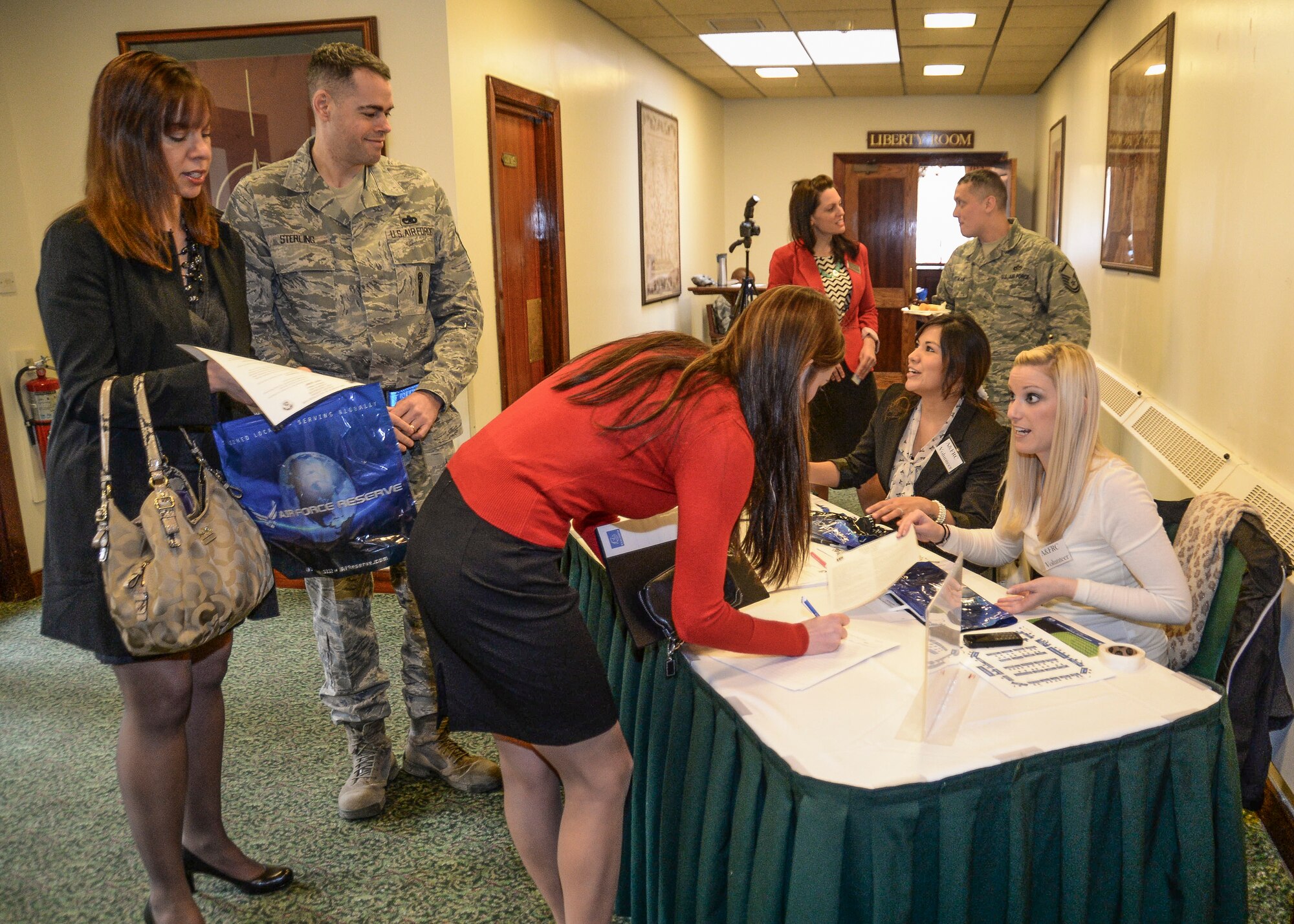 Airmen and Family Readiness volunteers, Eunice Taguinod and Arianne Pennington, help interested event-goers sign in to the Employment and Volunteer Fair at Eagle’s Landing on Royal Air Force Lakenheath, England, March, 19, 2014. The fair provided civilian and military personnel with insight on job and volunteer opportunities provided on base and in the local area. (U.S. Air Force photo by Airman 1st Class Nigel Sandridge/Released)