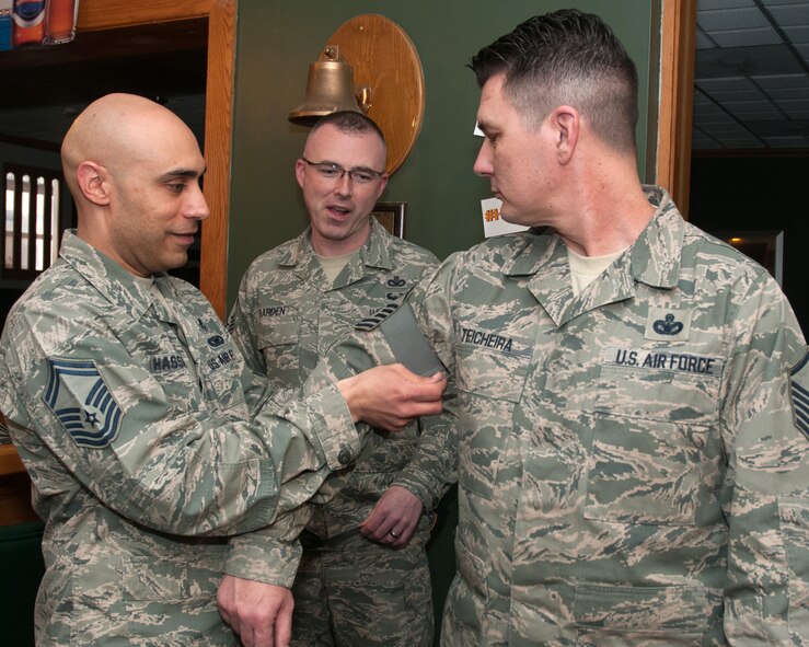 HANSCOM AIR FORCE BASE, Mass. – Senior Master Sgt. David Hassan presents Master Sgt. Shon Teicheira with senior master sergeant stripes at an E-8 promotion release ceremony at the Minuteman Commons March 20 as Senior Master Sgt. Joseph Barden looks on. Along with Teicheira, Master Sgt. Pattie Hassan and Master Sgt. Richard Olivarez (not pictured) were also selected for promotion to senior master sergeant. (U.S. Air Force photo by Mark Herlihy)
