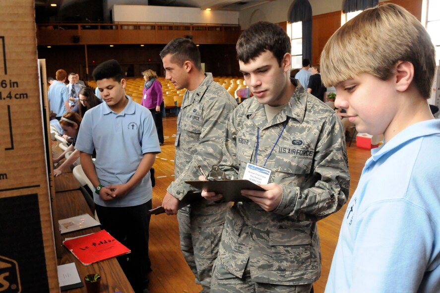 WOBURN, Mass. – 1st Lt. Evan Porter and Airman 1st Class Ray Rediger judge science fair projects at the St. Charles School here March 13. Students in grades five through eight displayed their projects for six volunteers from Hanscom. (U.S. Air Force photo by Linda LaBonte Britt) 