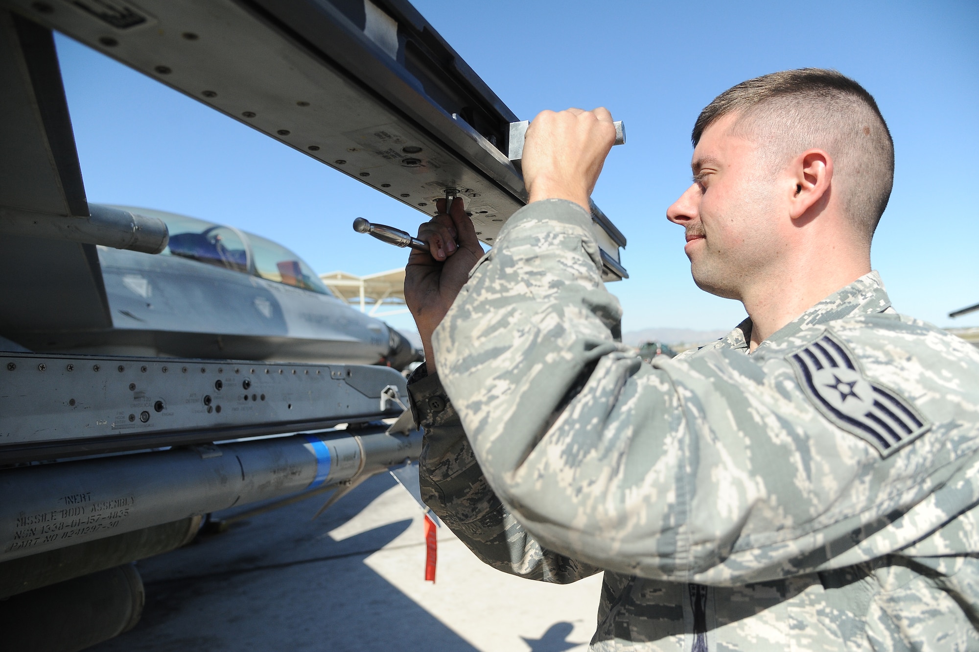 Staff Sgt. Daniel Baur, 310th Aircraft Maintenance Unit weapons load crew chief, performs a 90-day weapons inspection March 12 at Luke Air Force Base. The weapons inspection was of the LAU-129 missile launcher section of the F-16 Fighting Falcon. (U.S. Air Force photo/Airman 1st Class Pedro Mota)