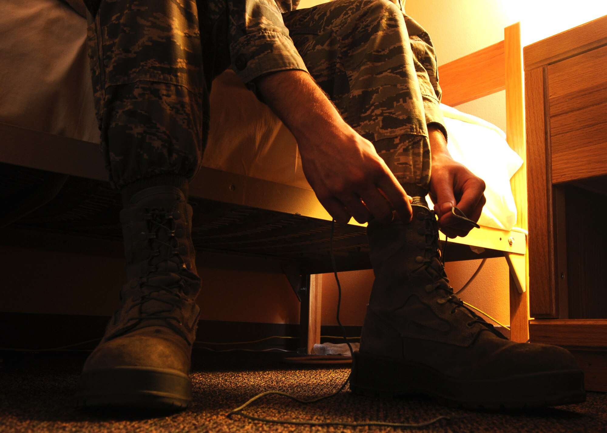 Airman 1st Class Brian Roupp, 341st Force Support Squadron missile chef, ties his combat boots at a missile alert facility at 5:30 a.m. to serve breakfast at 6 a.m. Missile chefs post to Malmstrom’s missile complex individually and are solely responsible for cooking, cleaning and maintaining MAF kitchens during their three-day tours. (U.S. Air Force photo/Senior Airman Katrina Heikkinen) 
