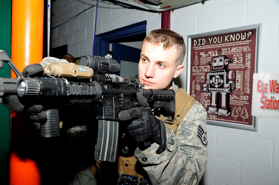 Staff Sgt. Kyle Hart, 341st Security Forces Group Tactical Response Force assaulter, simulates providing cover while his team clears a room behind him during a training exercise at the former Base Exchange at Malmstrom Air Force Base on March 17. During the training, Hart served as a team leader and provided his teammates with valuable information on tactics and maneuvers, which would be used in real-life scenarios and operations. (U.S. Air Force photo/Airman 1st Class Collin Schmidt)