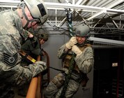 Tech. Sgt. Aaron Applewick, 341st Security Forces Group Tactical Response Force flight chief (left), and Senior Airman Justin Korus, 341st SFG TRF breacher (center), observe Senior Airman Bryan Montoya-Rodriguez, 341st SFG TRF assaulter, fast rope during a training session at the old Base Exchange March 17. During the training session, TRF members practiced basic fast-roping skills for rapid insertion into launch facilities. (U.S. Air Force photo/Airman 1st Class Collin Schmidt)