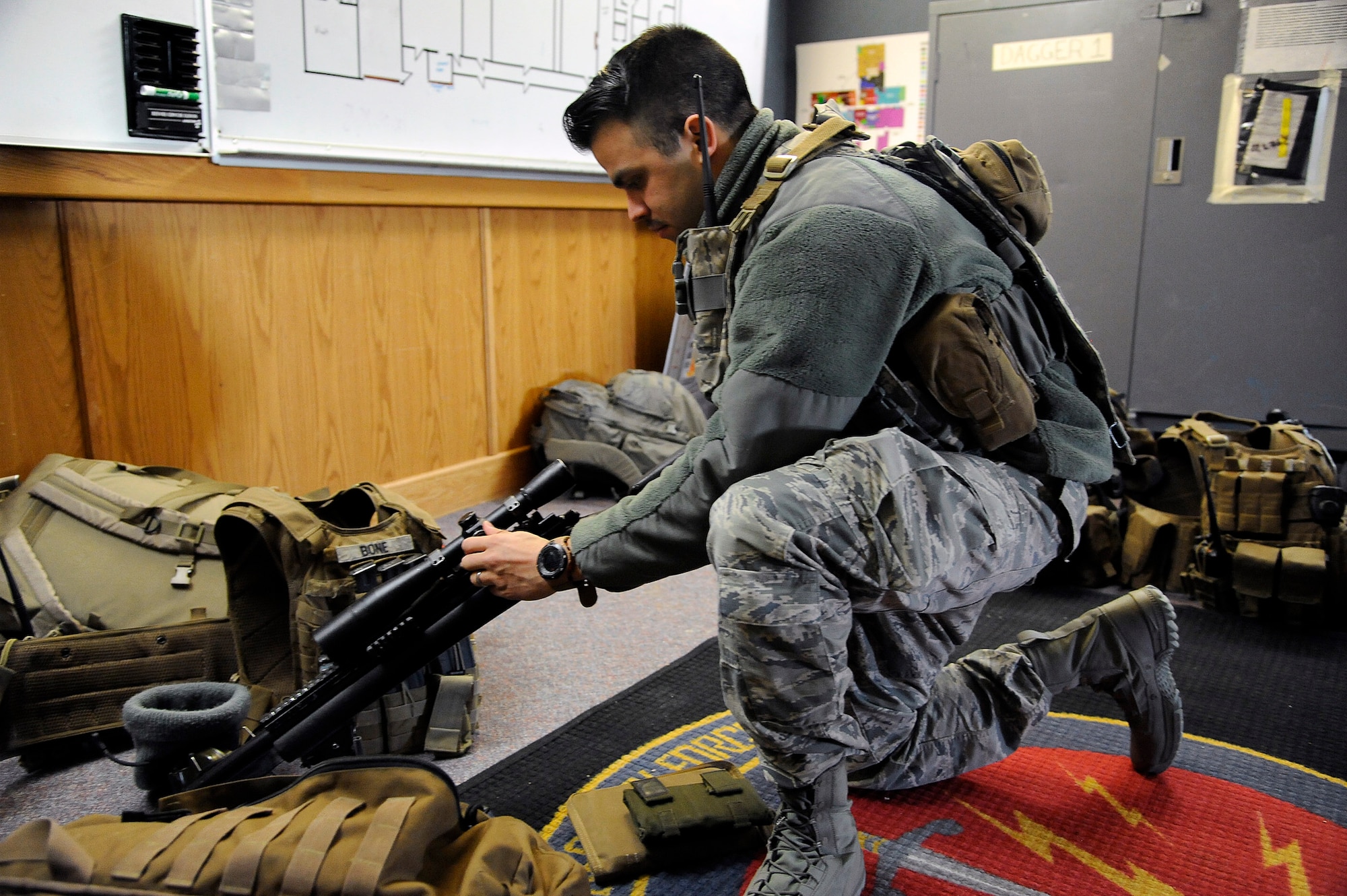 Senior Airman Matthew Dubon, 341st Security Forces Group Tactical Response Force nuclear advanced designated marksman, conducts a pre-mission check of his rifle and additional equipment required to conduct NADM duties. Before every assignment, TRF Airmen look over their gear and equip themselves with needed supplies for the mission at hand. (U.S. Air Force photo/Airman 1st Class Collin Schmidt)