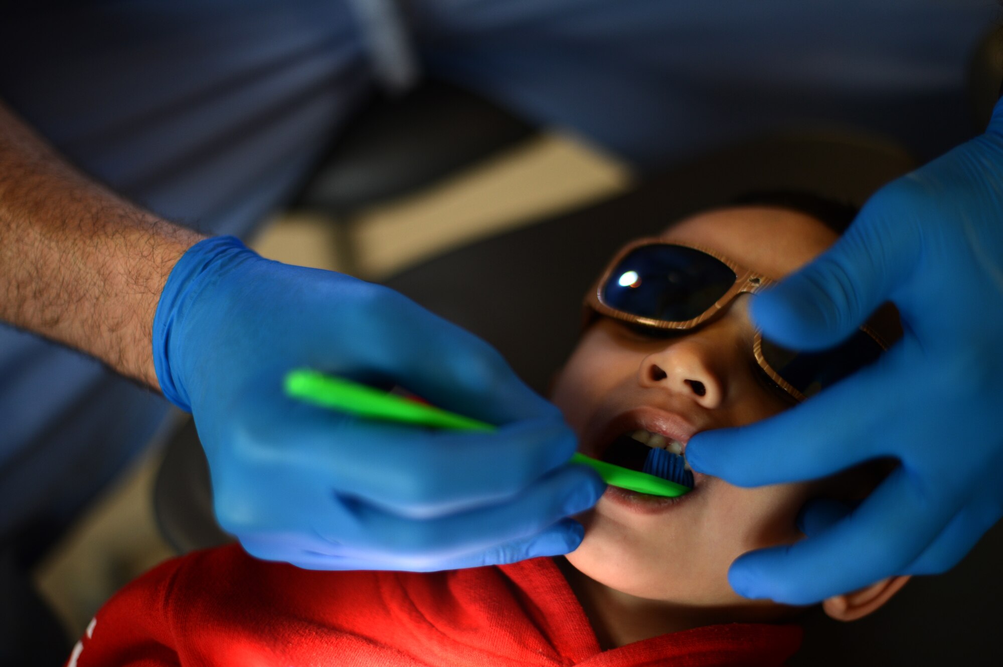 U.S. Air Force Capt. Brandon Pieper, 52nd Dental Squadron general dentist from Scottsbluff, Neb., cleans the teeth of Landon Schwarz, 4, during a walk-in clinic for children event at Spangdahlem Air Base, Germany, March 21, 2014. Landon is the son of U.S. Air Force Staff Sgt. Kristine Chavez-Schwarz, 52nd Logistics Readiness Squadron individual protective equipment supervisor from Chicago. Along with a check-up, dentists educate parents and their children on proper teeth cleaning procedures to fight cavities and gingivitis. (U.S. Air Force photo by Senior Airman Gustavo Castillo/Released)