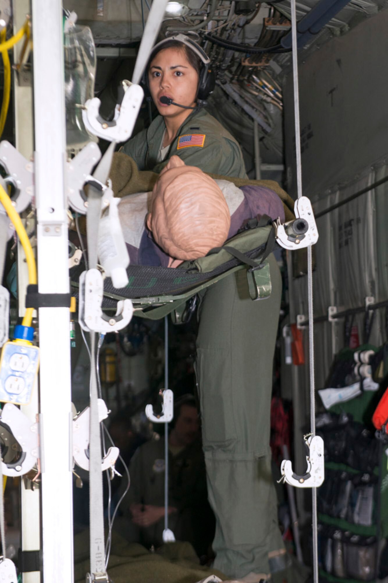 1st Lt. Alyssa Sandquist, a flight nurse, with the 36th Aeromedical Evacuation Squadron, makes sure that the wounded in litters are secure aboard a C-130H. She is part of a medical evacuation training flight from Pope Army Airfield Mar. 10, 2014. (Photo by Lewis Perkins/Paraglide)