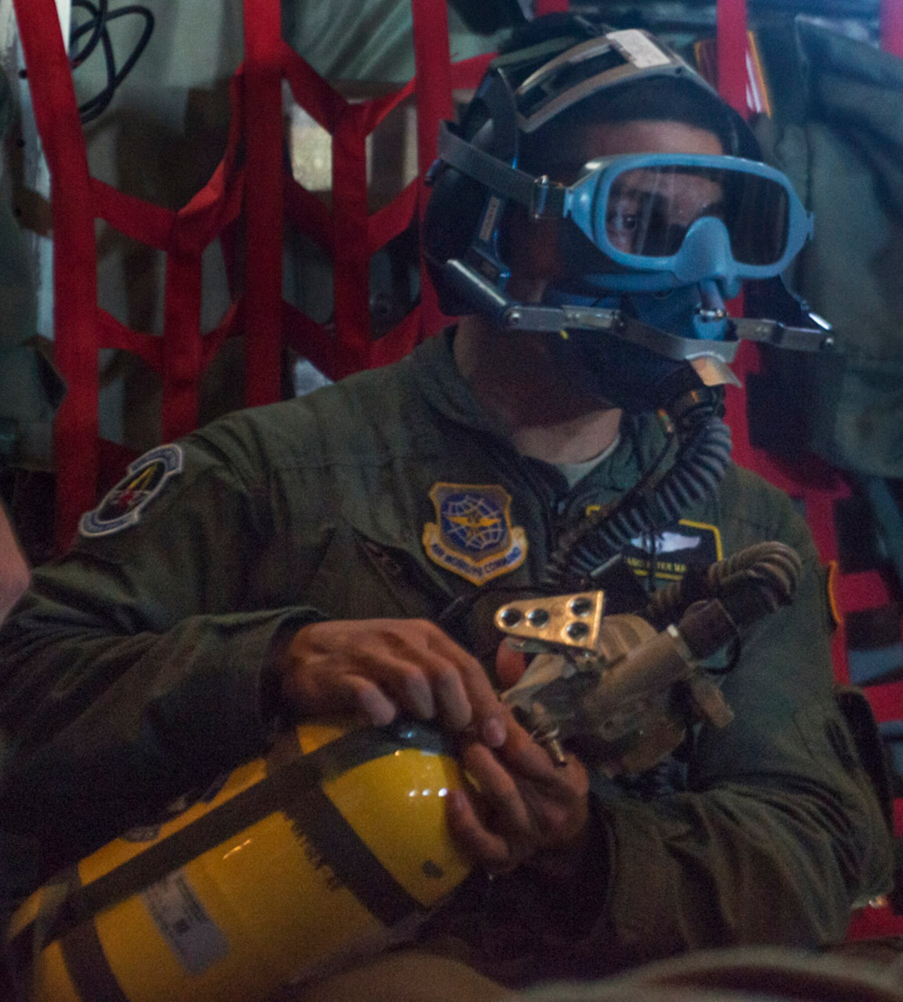 Staff Sgt. Ryan Garcia, having put on a breathing mask, waits for the all clear during an in flight fire drill. (Photo by Lewis Perkins/Paraglide)