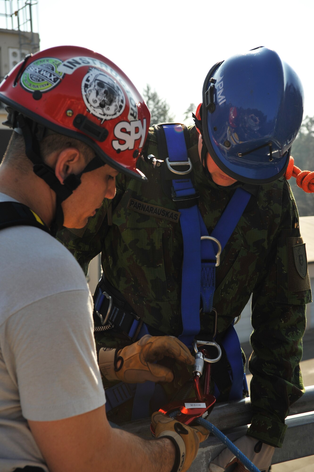 Tech. Sgt. James Hickman, 435th Construction and Training Squadron contingency and rescue training NCOIC, assists a Lithuanian military member before he repels down the building during the rescue portion of the Firefighters Fundamentals Course, March 13, 2014, at Ramstein Air Base, Germany. The course consisted of hands-on simulations and classroom portions allowing service members to learn about different fire rescue techniques. (U.S. Air Force photo/Senior Airman Hailey Haux)