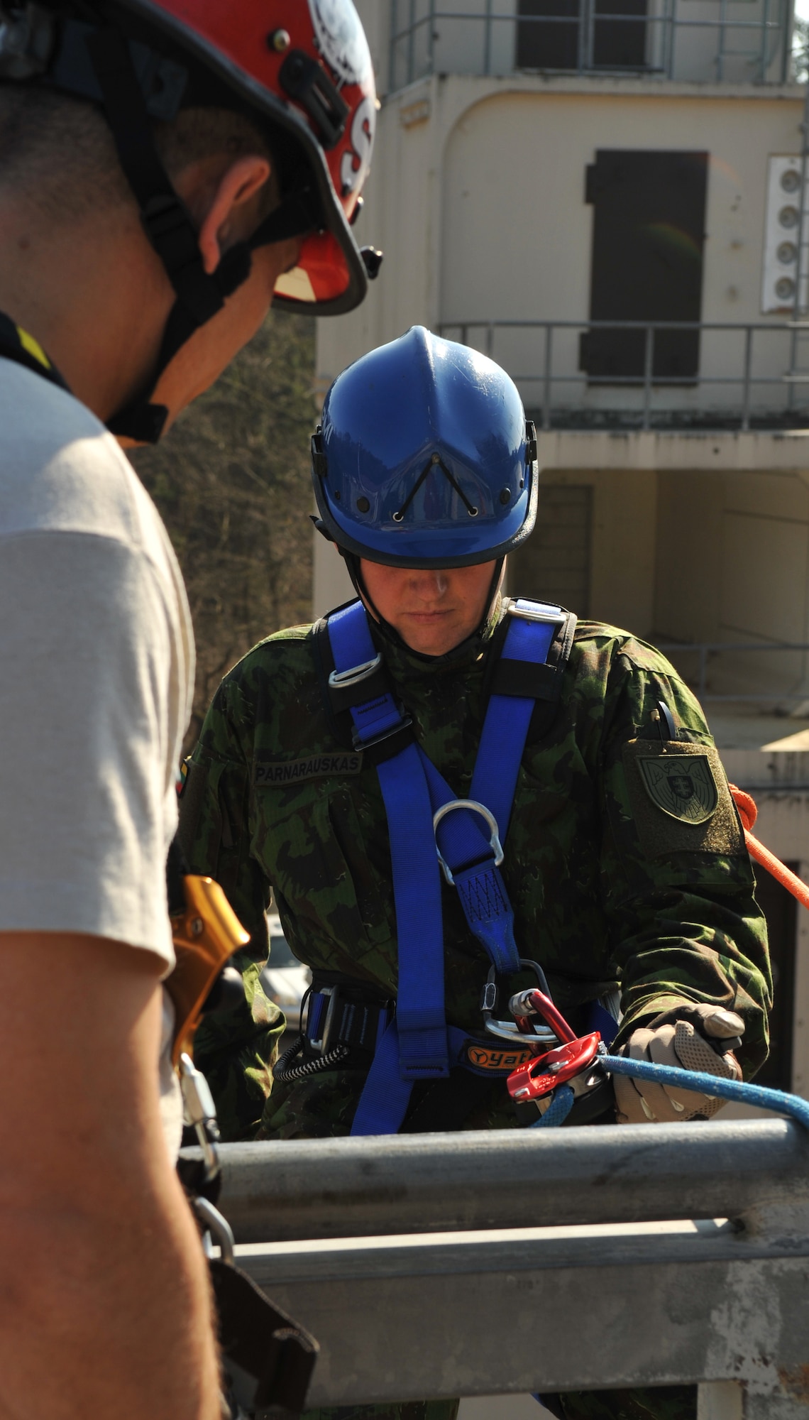 A Lithuanian military member prepares to repel down a building during the rescue portion of the Firefighters Fundamentals Course, March 13, 2014, at Ramstein Air Base, Germany. The course consisted of hands-on simulations and classroom portions allowing service members to learn about different fire rescue techniques. (U.S. Air Force photo/Senior Airman Hailey Haux)