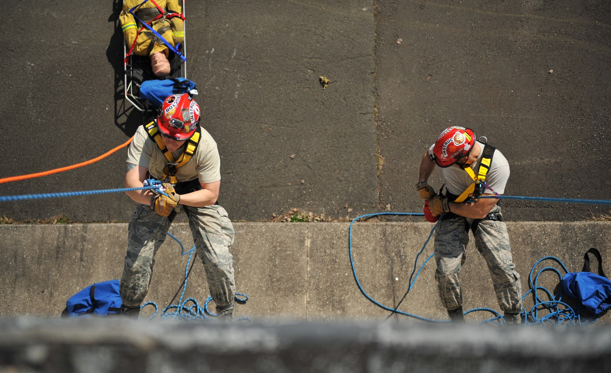 Airmen from the 435th Construction and Training Squadron show Lithuanian and Bosnian military members how to rescue a victim from a tall building during the Firefighters Fundamentals Course, March 13, 2014, at Ramstein Air Base, Germany. The course consisted of hands-on simulations and classroom portions allowing service members to learn about different fire rescue techniques. (U.S. Air Force photo/Senior Airman Hailey Haux)