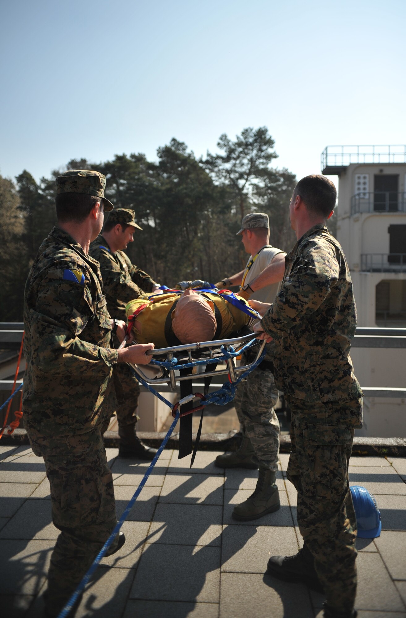 Bosnian military members assist in lifting a simulated victim during the rescue training portion of the Firefighters Fundamentals Course, March 13, 2014, at Ramstein Air Base, Germany. The course consisted of hands-on simulations and classroom portions allowing service members to learn about different fire rescue techniques. (U.S. Air Force photo/Senior Airman Hailey Haux)