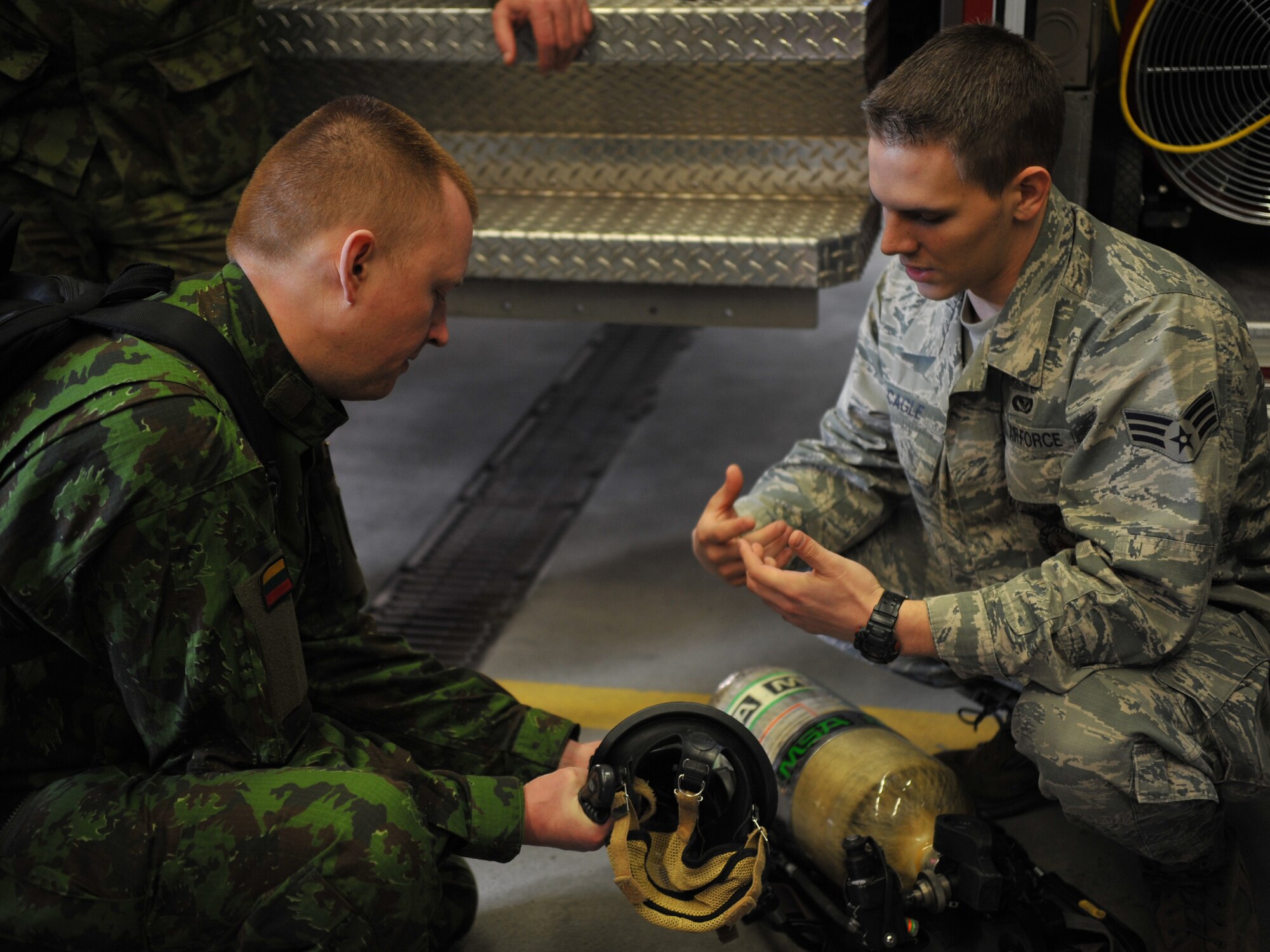 Senior Airman Samuel Cagle, 86th Civil Engineer Squadron firefighter, explains the different functions of their fire trucks to the Lithuanian and Bosnian military members during a tour of the fire house March 12, 2014, at Ramstein Air Base, Germany. The tour was one of many stops the Lithuanians and Bosnians made during the week-long Firefighters Fundamental Course. (U.S. Air Force photo/Senior Airman Hailey Haux)