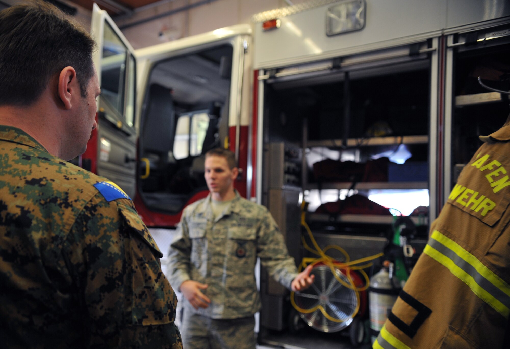 Senior Airman Samuel Cagle, 86th Civil Engineer Squadron firefighter, explains the different functions of their fire trucks to the Lithuanian and Bosnian military members during a tour of the fire house March 12, 2014, at Ramstein Air Base, Germany. The tour was one of many stops the Lithuanians and Bosnians made during the week-long Firefighters Fundamental Course. (U.S. Air Force photo/Senior Airman Hailey Haux)